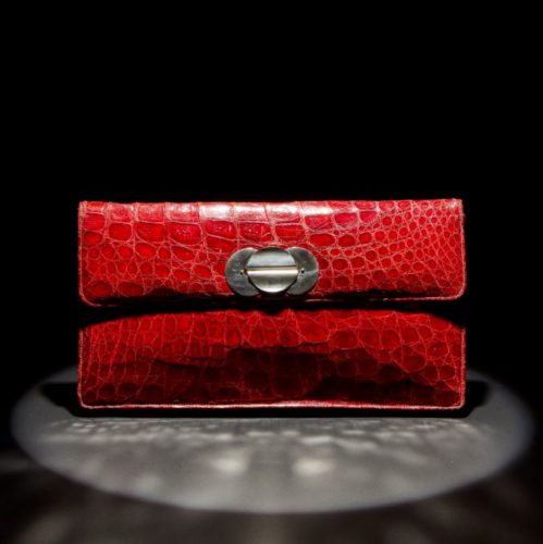 A large red crocodile clutch bag from date c. 1945-50 Soft supple skins through out the interior is in beige leather with crocodile trim to pockets it retains its original small change purse, the silvered clasp to the front is in good strong condition. There is no makers mark, origin South American made for the US market.