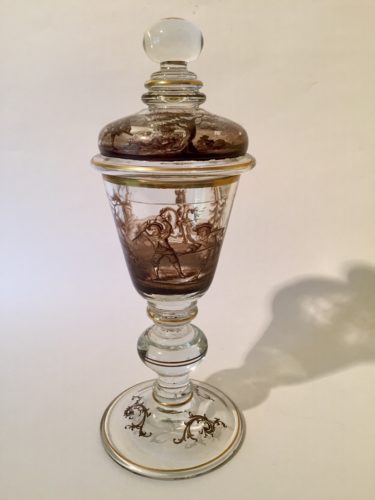 This is a covered goblet produced in Bohemia . The technique is known as schwarzlot, the whole design being executed in black. This particular piece is an example of 19th century historismus work. It was probably created by Josef Lenhardt at Steinschonau in Bohemia about 1880.